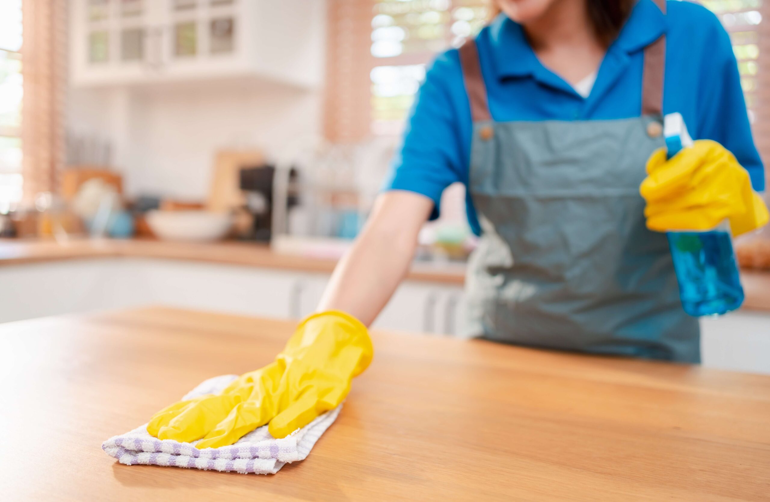 a person wearing a glove and cleaning a table